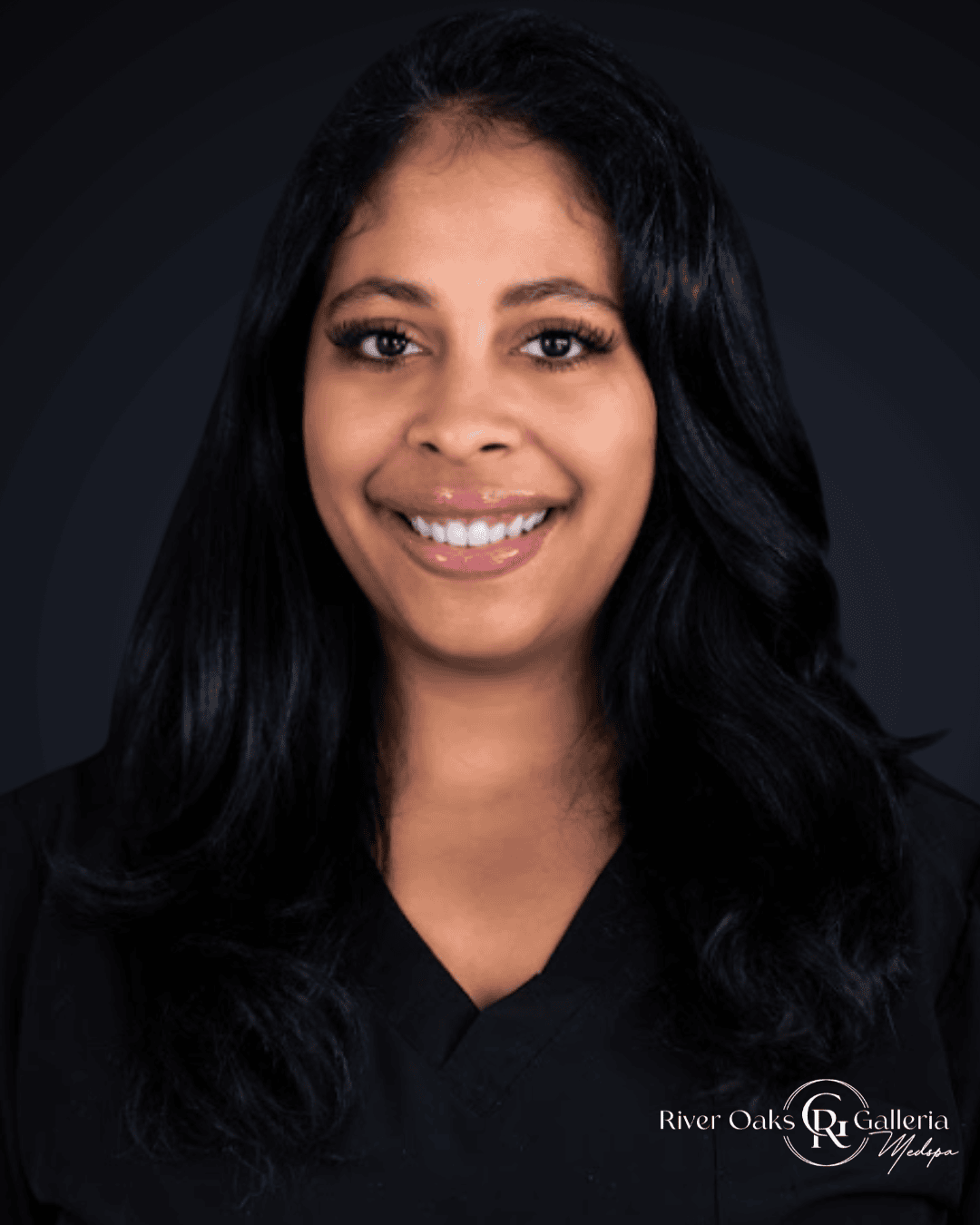 Woman with long black hair smiling, wearing a black top, dark background.